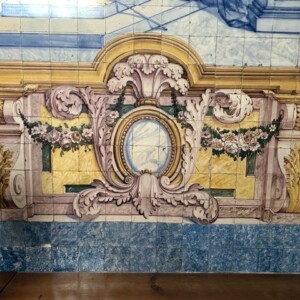 Painel de azulejos com ilusão arquitetónica, refletindo a mestria da azulejaria barroca portuguesa.
