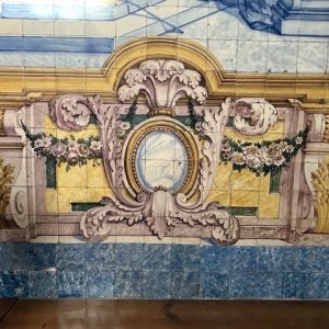 Painel de azulejos com ilusão arquitetónica, refletindo a mestria da azulejaria barroca portuguesa.