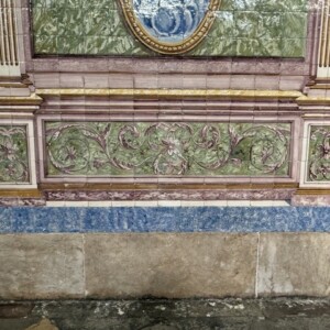 Base decorativa de painel azulejar com motivos vegetalistas e arquitetura simulada.