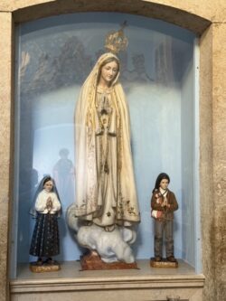 Representa Nossa Senhora de Fátima, ladeada por Santa Jacinta e São Francisco Marto.