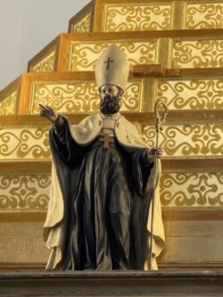 Figura episcopal — poderá ser Santo Agostinho, São Brás ou outro bispo venerado.