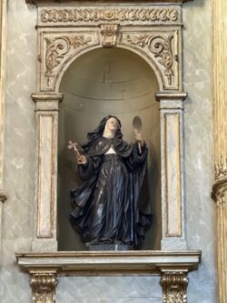Imagem de Santa com crucifixo e palma do martírio .